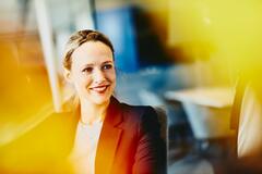 Woman in suit in an office smiling